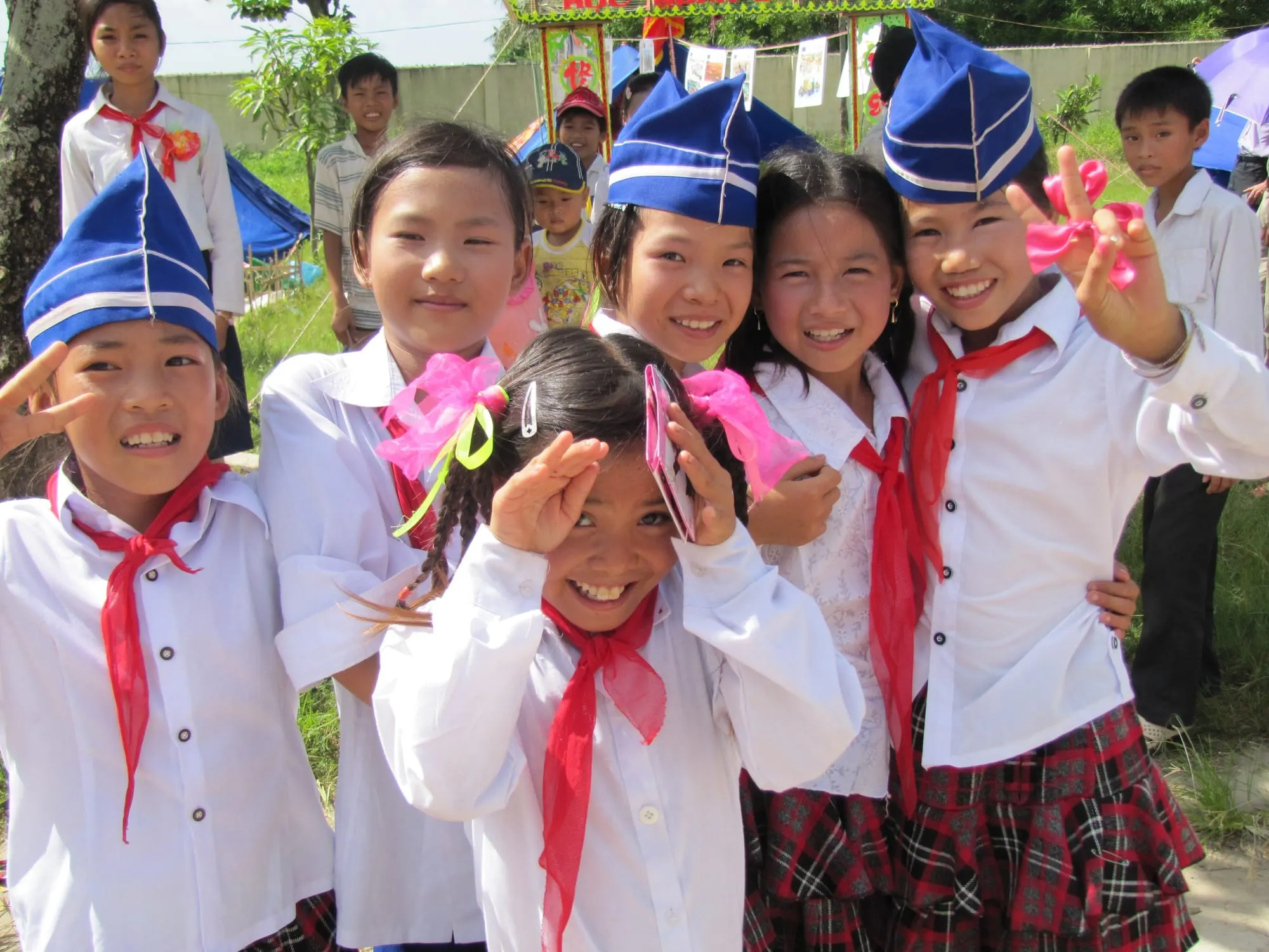 Nhóm học sinh tiểu học đeo khăn quàng đỏ cười rạng rỡ